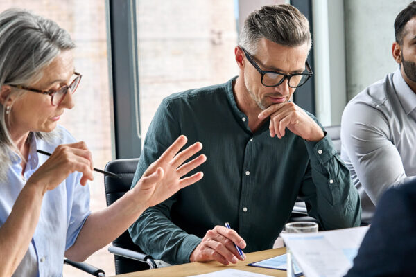 Strategic Growth - Man discusses company growth strategy with colleagues